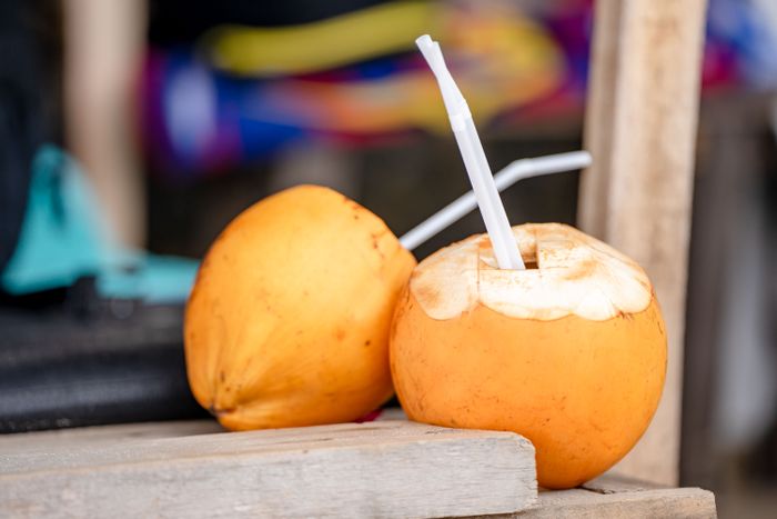 Two king coconuts served with straws